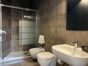 a bathroom with a toilet and a sink and a shower at Neko Boutique Hotel in Cagliari