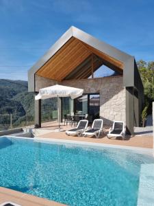 a villa with a swimming pool and a house at Casas do Bau in Vieira do Minho