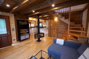 sala de estar con sofá azul y escalera en CHALET PRATI OGRCA, en Valbruna