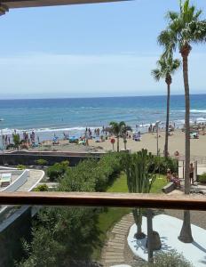 uitzicht op het strand vanaf het balkon van een resort bij Apartamentos Los Papagayos in San Agustin