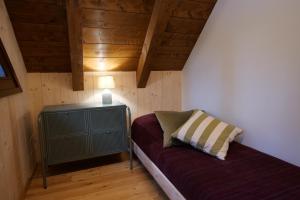 Habitación pequeña con sofá y lámpara. en CHALET PRATI OGRCA, en Valbruna