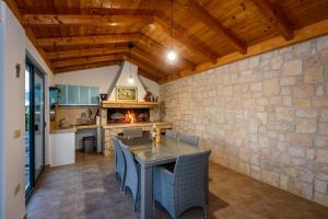 a kitchen and dining room with a stone wall at Villa Jerkovic in Metković