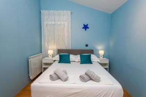 a blue bedroom with a large white bed with pillows at Villa Jerkovic in Metković +43 photos