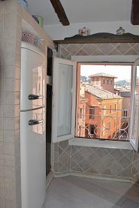 a kitchen with a large window and a refrigerator at Mansarda Teatro Duse Centro in Bologna