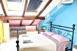 1 dormitorio con 1 cama con paredes de color rosa y azul en Mansarda Teatro Duse Centro, en Bolonia