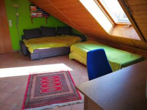 a attic room with two beds and a couch at Wunderschöne Aussicht garantiert in Trechtingshausen