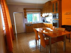 a kitchen with a wooden table and a dining room at Casa do Carvalho in Ribeira de Pena