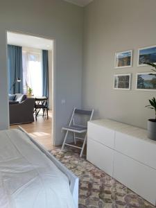 a white bedroom with a bed and a living room at Zane's apartment in Valmiera