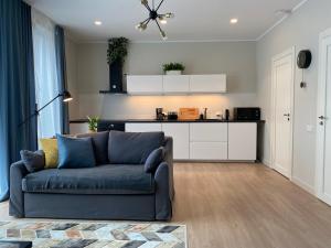 a living room with a blue couch and a kitchen at Zane's apartment in Valmiera +5 photos