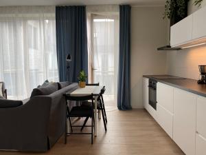 een keuken en een woonkamer met een tafel en een bank bij Zane's apartment in Valmiera