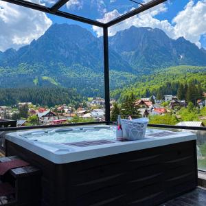 a hot tub with a view of mountains at Kayus in Buşteni