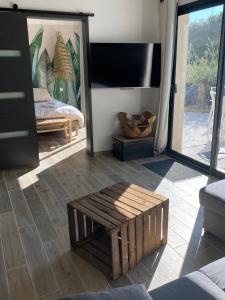 a living room with a couch and a tv at Petit nid douillet en Luberon avec spa in Ansouis