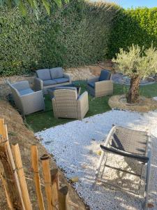 een groep stoelen en stoelen in een tuin bij Petit nid douillet en Luberon avec spa in Ansouis