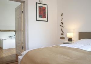 a white bedroom with a bed and a bathroom at Ferienwohnungen Schlei 42 in Schleswig