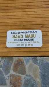 a sign for a guest house on a wooden door at Guesthouse Mabu - 4 Newly Built Rooms in the Heart of Mestia in Mestia