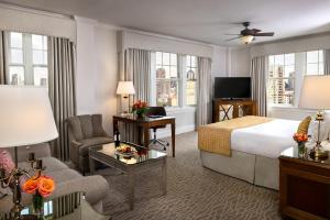 a hotel room with a bed and a living room at Warwick Melrose Hotel in Dallas