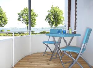 a blue table and two chairs on a balcony at Ferienwohnungen Schlei 42 in Schleswig