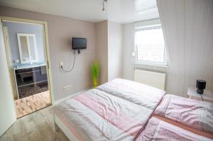 a bedroom with a large bed and a mirror at Ferienwohnung am Starenkasten in Berumbur