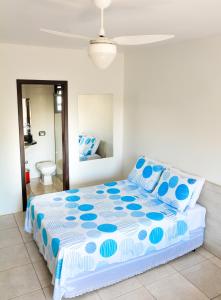 ein Schlafzimmer mit einem Bett mit blau-weißer Bettwäsche in der Unterkunft Classe Pousada in Imbé