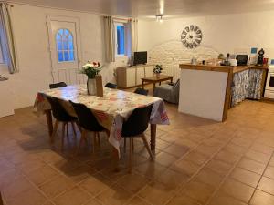 een eetkamer met een tafel en stoelen bij Gîte du Bois Pennier, au calme , à 15 km des plages du Débarquement in Picauville