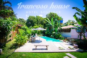 トランコーゾにあるTrancoso House - Hotel Boutiqueのピクニックテーブルとパラソル付きのリゾートプール