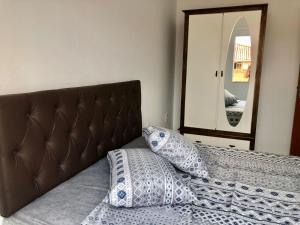 a bed with two pillows in front of a mirror at Apartamento em Floripa -ao lado do Aeroporto e juntinho as praias do Sul da Ilha in Florianópolis