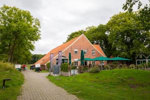 a large red brick building with a building at Ferienwohnung am Starenkasten in Berumbur