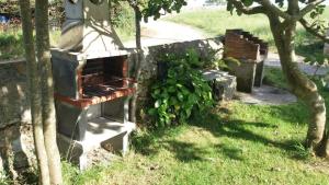 a stone wall with a brick oven in the grass at Hospedaje Vistamar in Isla