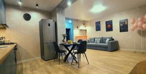 Нові Ексклюзивні Апартаменти біля Софіївського Парку في أومان: مطبخ وغرفة معيشة مع طاولة وكراسي