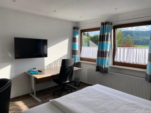 a bedroom with a desk and a computer and a window at Am Irrenbächle in Albstadt