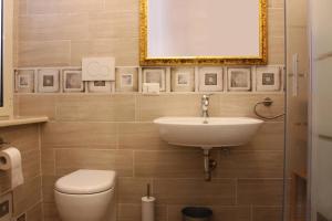 uma casa de banho com um lavatório, um WC e um espelho. em Casa Maria a San Pietro em Roma