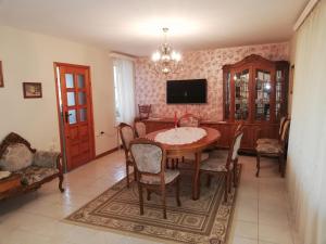 a dining room with a table and chairs and a tv at Сара in Gabrovo