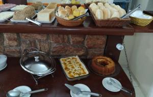 een tafel met verschillende soorten brood en gebak bij Pousada Areias Brancas in Búzios