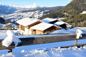 a house covered in snow on a mountain at Ritschhof in Castelrotto