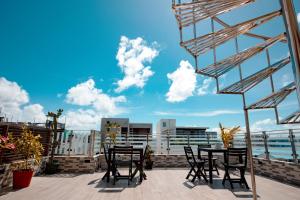 a patio with chairs and a table on a roof at Araamview in Hulhumale