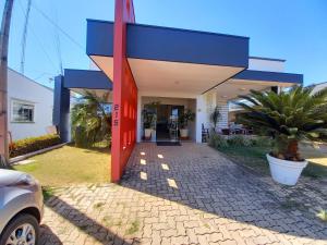 a house with a blue and red front door at Hotel Mandino in Alta Floresta