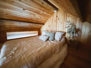 1 dormitorio con 1 cama en una cabaña de madera en Casa rural familiar con vistas al rio en Galicia, en Puentesampayo
