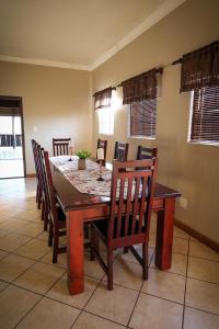 a dining room with a wooden table and chairs at Waterval Self-Catering Holiday Home in Sabie