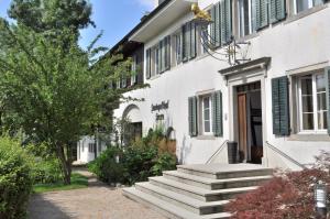 una casa blanca con escaleras que conducen a una puerta en Landgasthof Leuen, en Uitikon