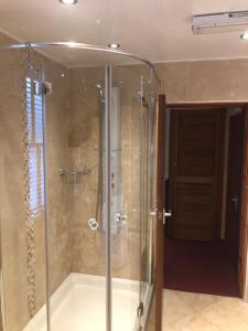 a shower with a glass enclosure in a bathroom at Bank Quay, Caernarfon in Caernarfon