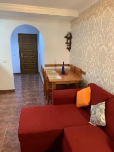 ein Wohnzimmer mit einem roten Sofa und einem Tisch in der Unterkunft Apartamento Mar y Montaña in Los Silos