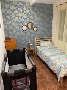 ein Schlafzimmer mit einem Bett und einem Stuhl darin in der Unterkunft Apartamento Mar y Montaña in Los Silos