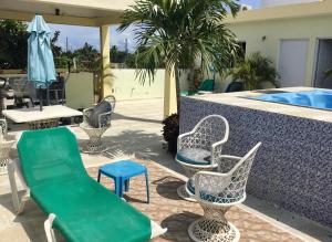 - un groupe de chaises et de tables à côté d'une piscine dans l'établissement Aparthotel El Sol by AirPort SDQ, à Boca Chica