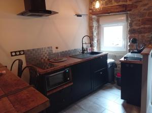 a kitchen with a sink and a stove top oven at L'espaco in Saint-Jeure-dʼAy
