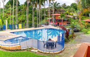 ein großer Pool mit einem blauen Zaun um ihn herum in der Unterkunft Finca Hotel El Tizon in Quimbaya