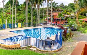 una gran piscina con una valla azul alrededor en Finca Hotel El Tizon, en Quimbaya