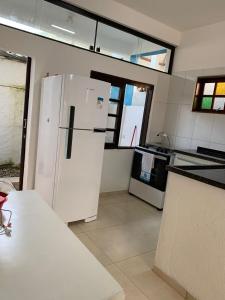 a kitchen with a white refrigerator in a room at arco iris in Camburi