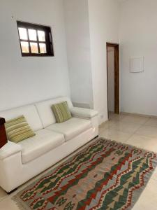a white couch in a living room with a rug at arco iris in Camburi