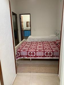 a bedroom with a bed with a red blanket at arco iris in Camburi