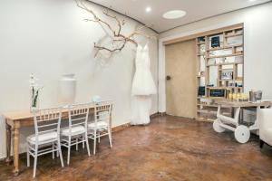 モンテゴ・ベイにあるIberostar Rose Hall Beachのテーブルと椅子、壁掛けのドレスが備わる客室です。